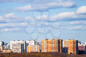 blue sky with clouds over urban multistorey houses on sunny March day