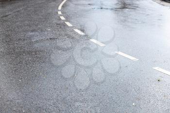 wet surface of two-lane road in city after autumn rain