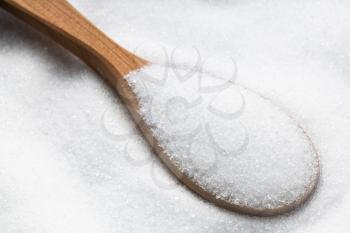wooden spoon with sugar substitute - crystalline extract of stevia plant close up on pile