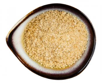 top view of demerara brown cane sugar in ceramic bowl isolated on white background