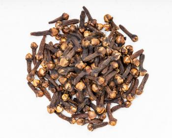 top view of pile of whole dried cloves close up on gray ceramic plate