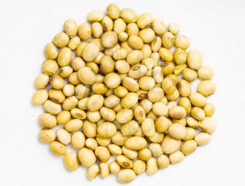 top view of pile of raw dried soybeans close up on gray ceramic plate