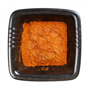 top view of chili powder from cayenne pepper in black bowl isolated on white background
