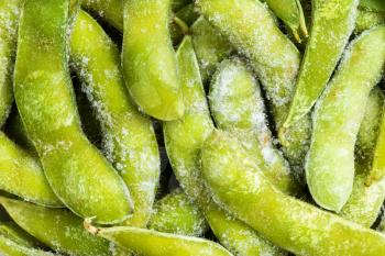 food background - many frozen Edamame (unripe soybeans) pods close up