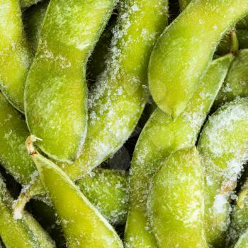 square food background - frozen Edamame (unripe soybeans) pods close up