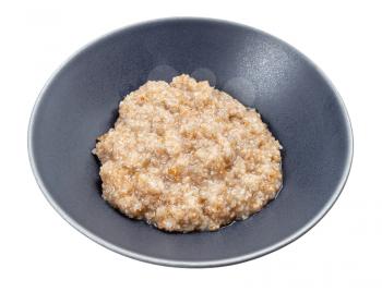 boiled porridge from crushed rye groats in gray bowl isolated on white background