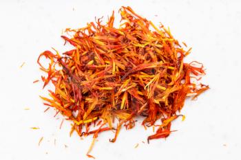 top view of pile of dried safflower petals close up on gray ceramic plate