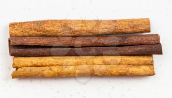 top view of three sticks of cassia cinnamon close up on gray ceramic plate