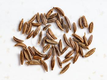 several caraway seeds close up on gray ceramic plate