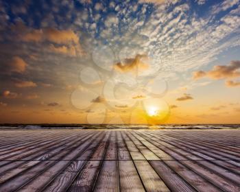 Wooden surface of planks pier under sunset dramatic sky