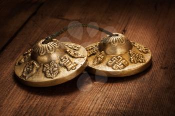 Tibetan Buddhist tingsha cymbals on wooden background