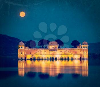 Vintage retro hipster style travel image of Rajasthan landmark - Jal Mahal (Water Palace) on Man Sagar Lake in the evening in twilight with grunge texture overlaid.  Jaipur, Rajasthan, India