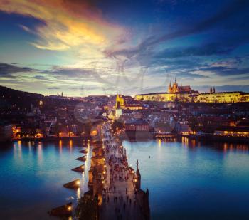 Vintage retro hipster style travel image of night aerial view of Prague castle and Charles Bridge over Vltava river in Prague, Czech Republic. Prague, Czech Republic