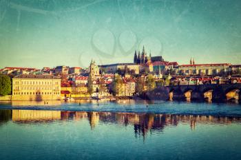 Vintage retro hipster style travel image of Mala Strana and  Prague castle over Vltava river with grunge texture overlaid. Prague, Czech Republic