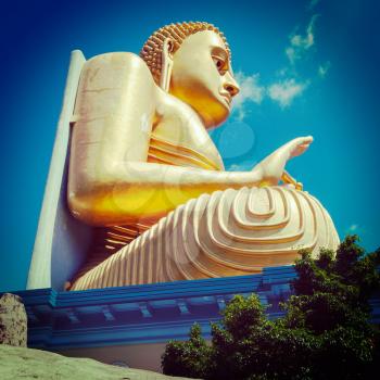 Vintage retro hipster style travel image of gold Buddha. Golden Temple, Dambulla, Sri Lanka