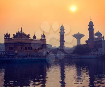 Vintage retro hipster style travel image of Sikh gurdwara Golden Temple (Harmandir Sahib) on sunrise. Amritsar, Punjab, India