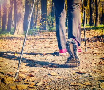 Close up of hinking woman feet and nordic walking poles. Vintage retro effect filtered hipster style image