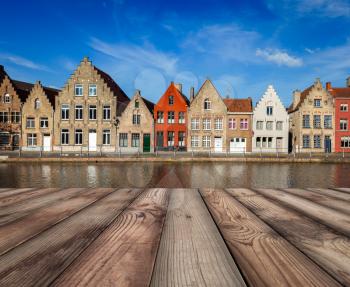 Wooden planks table with typical European Europe cityscape view -  canal and medieval houses in background. Brugge, Belgium