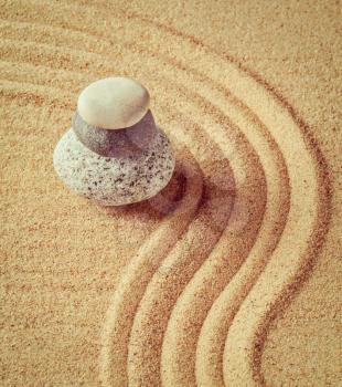 Vintage retro effect filtered hipster style image of Japanese Zen stone garden - relaxation, meditation, simplicity and balance concept  - pebbles and raked sand tranquil calm scene