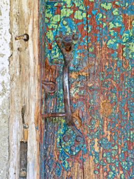 Old wooden door and metal handle taken closeup.