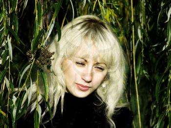 Pretty blonde in a green willow thickets.Tonal correction.