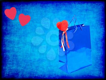 Blue Valentines gift bag and red hearts on blue grungy background with empty space.