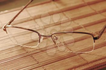 Reading glasses on a table with soft light taken closeup.