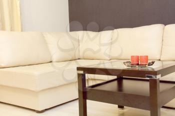 Interior with white corner leather sofa and coffee table.