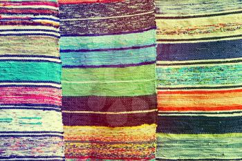 Multicolored handmade rugs taken closeup as abstract background.Toned image.