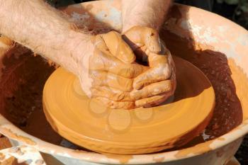 Potter hands taken closeup in the process of the pottery manufacturing.