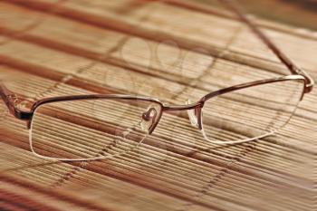 Reading glasses on a table taken closeup.