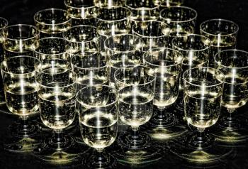White sparkling wine in glasses on stars flare effect.Toned image.