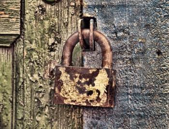 Old metal lock on wooden door taken closeup.Toned image.