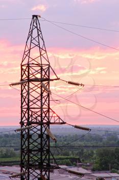 Electricity pylon on cloudy sunset sky background taken closeup.