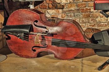 Contrabass on concert stage near old brick wall.Retro style toned image.
