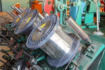 Steel wire spools of Braiding machine closeup.Flexible metal hose production line.
