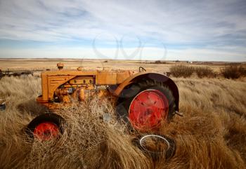 Tumbleweeds piled against abandoned tractor