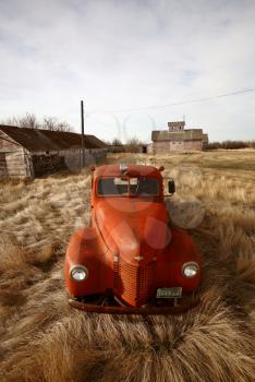 Old farm truck abandoned near unused wooden buildings
