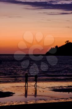 sunset near a mountain in nosy be madagascar and two people in the beach