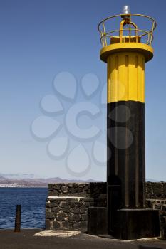lighthouse and harbor pier boat in the blue sky   arrecife teguise lanzarote spain
