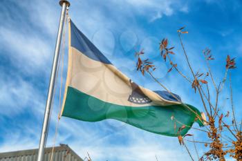 blur  in lesotho waving national flag in the cloudy sky