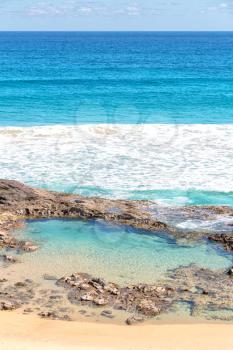 in  australia fraser island the beach near the rocks in the  wave of ocean