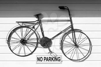  a no parkin signal in the garage door    and antique bicycle hanging 