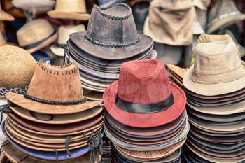 in a old market lots of colorated hats  like background clothes