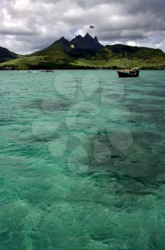 tropical lagoon hill navigable  froth cloudy  pirate boat  and coastline in Deer Island mauritius