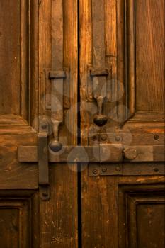 brown iron safety lock in a closed wood  door in naples italy