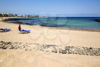 umbrella people footstep coaststone  volcanic spain  water in lanzarote  sky cloud beach  and summer 
