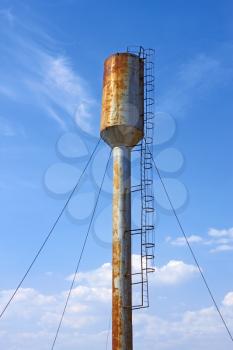Large old metal water tower on the background of blue sky