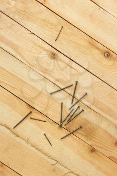 Nails are scattered on a wooden shield with a new parallel boards