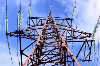 High-voltage electric lattice tower with wires and insulators against the sky